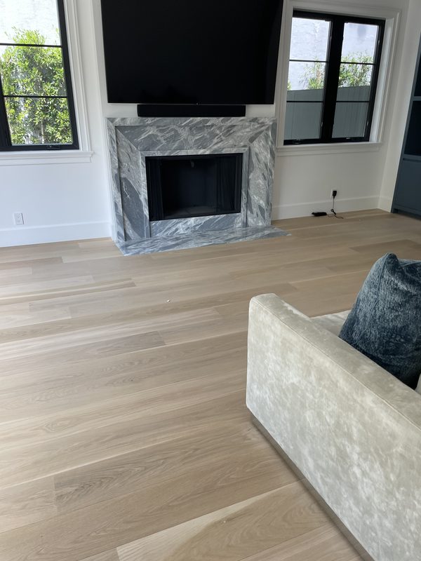 Living room with light oak floor and a marble fireplace